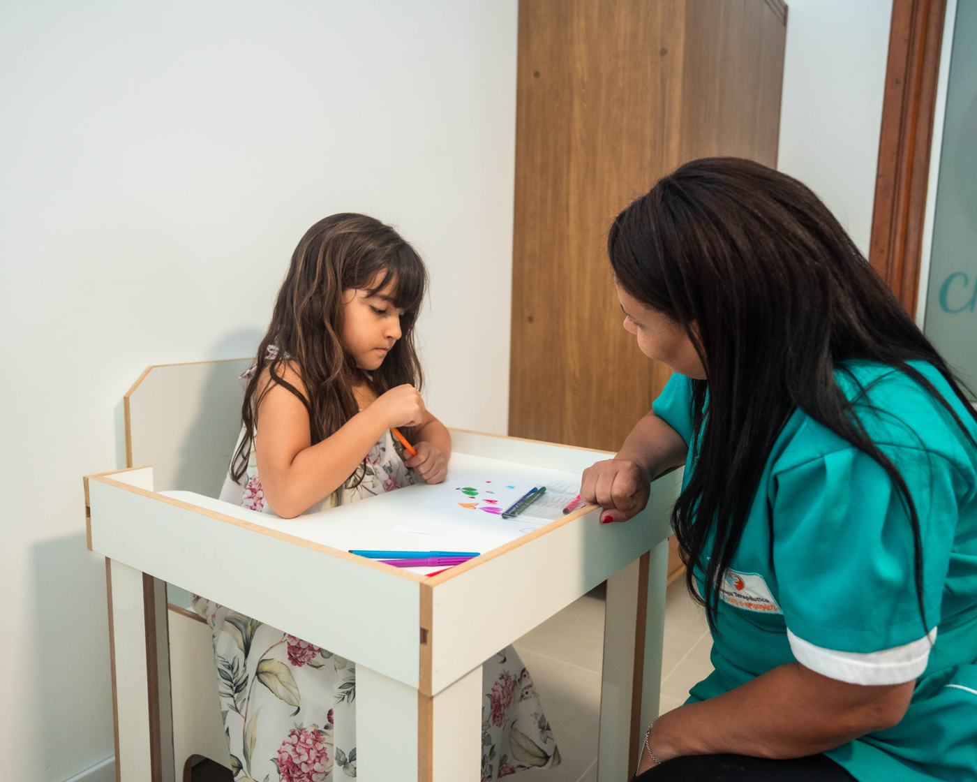 Criança em atividade de mesa com terapeuta